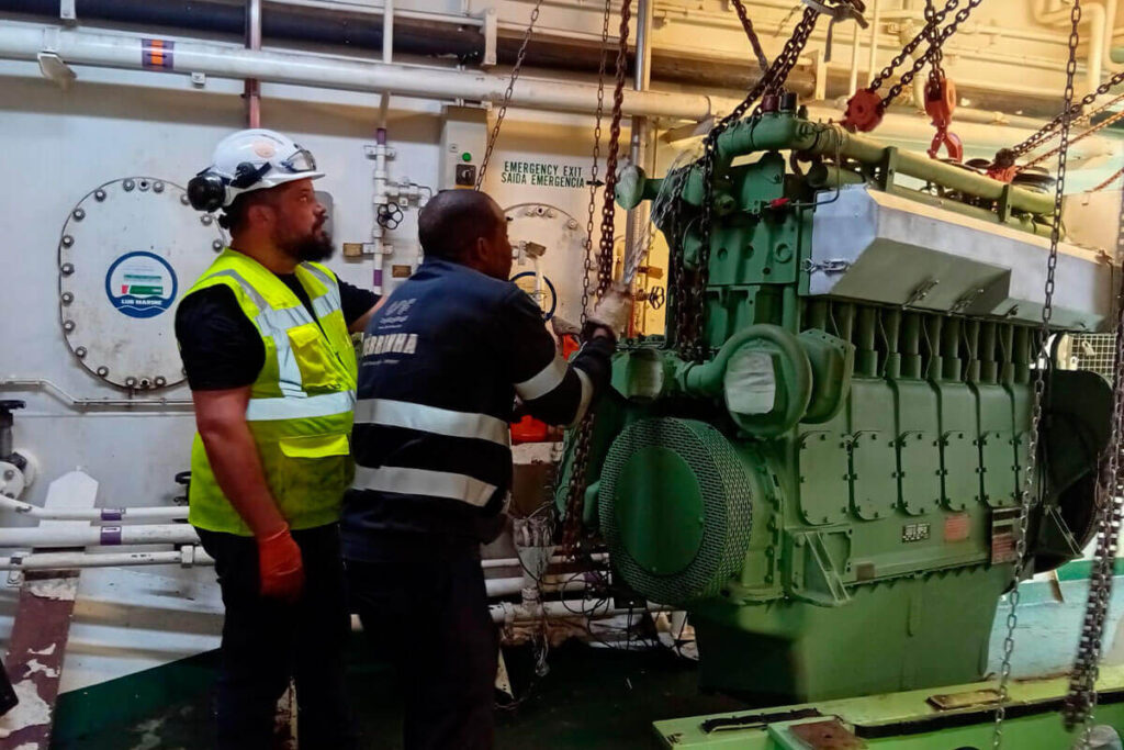 Equipa técnica da MASAPI a realizar reparação de motor industrial a bordo de navio, com uso de guinchos e equipamento de elevação.